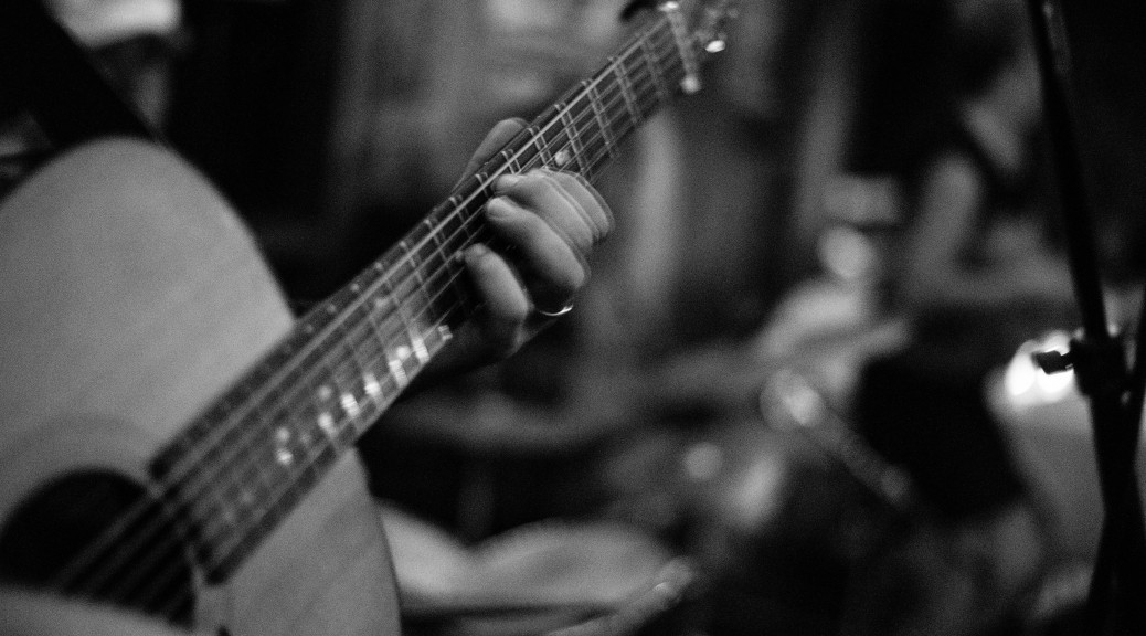 photo of playing an acoustic guitar